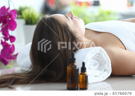 Girl lying at home under towel after massage Girl lying at home under towel after massage 65766079