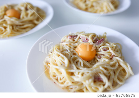 Carbonara pasta with egg yolk and bacon closeup background Carbonara pasta with egg yolk and bacon closeup background 65766878
