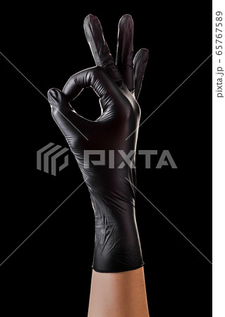 Hand in black gloves holding something with two Hand in black gloves holding something with two 65767589