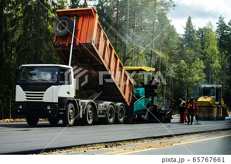 People on road equipment build a concrete road People on road equipment build a concrete road 65767661