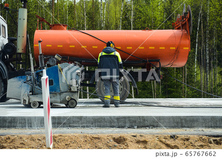 People on road equipment build a concrete road People on road equipment build a concrete road 65767662
