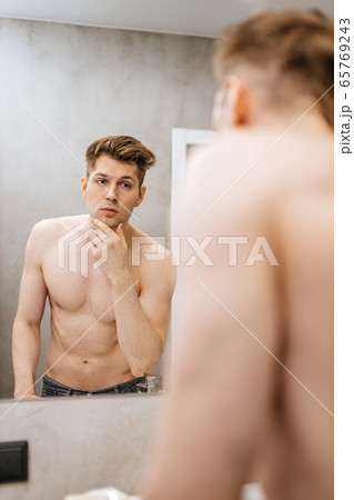 gorgeous caucasian muscular man look at reflection on mirror gorgeous caucasian muscular man look at reflection on mirror 65769243