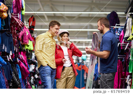 attractive couple stand with consultant of sportswear store attractive couple stand with consultant of sportswear store 65769459