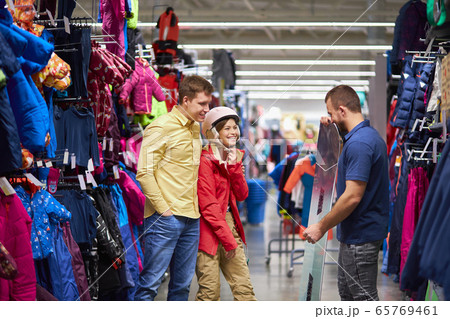 customers and consultant stand in the department of snowboards and skis customers and consultant stand in the department of snowboards and skis 65769461