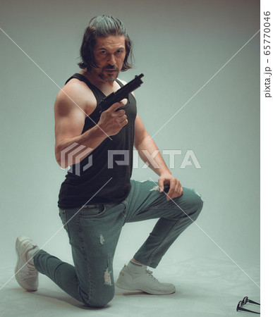 Action hero muscled man holding a gun,Studio shot Action hero muscled man holding a gun,Studio shot 65770046