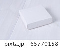 White box on wooden white table. Stock photo. White box mockup for product and advertising with cover on white wooden background. Side view. Delivery service concept. Blank package for your design 65770158