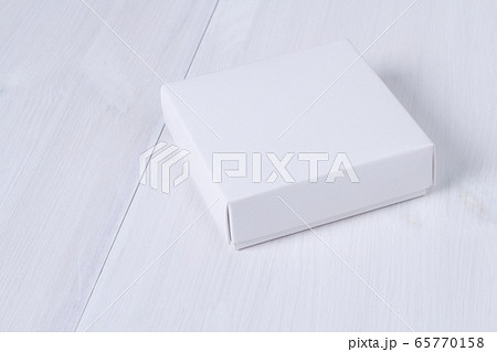 White box on wooden white table. Stock photo. White box mockup for product and advertising with cover on white wooden background. Side view. Delivery service concept. Blank package for your design White box on wooden white table. Stock photo. White box mockup for product and advertising with cover on white wooden background. Side view. Delivery service concept. Blank package for your design 65770158