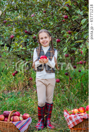 Portrait of a cute girl in a farm garden with a 65771218