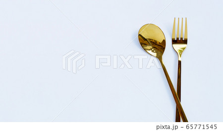Golden spoon and fork on white background. 65771545