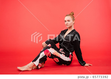Attractive woman in black pyjamas.She is sitting 65773392