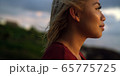 Profile of young woman takes in a sunset while on vacation  65775725