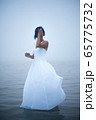 Cute shy girl covers her face in white dress and blue hair looks as if she is drifting by water  65775732