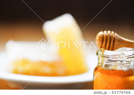 Fresh honey sweet in jar glass with wooden dipper 65776566