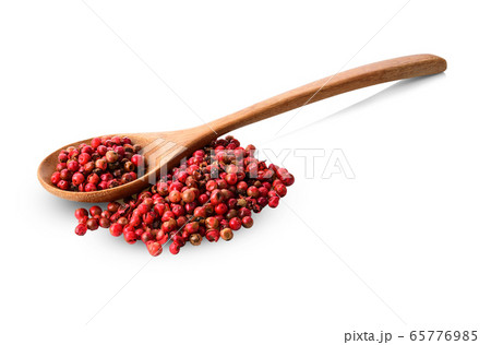 Red peppercorns in wooden spoon on a white 65776985