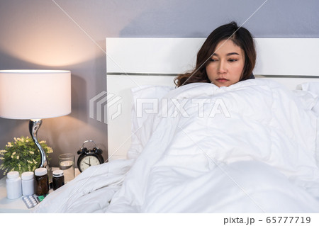 sick woman feeling cold in blanket on bed at home sick woman feeling cold in blanket on bed at home 65777719