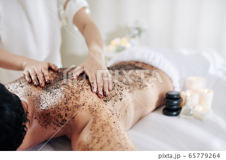 Cosmetologist applying coffee peeling 65779264