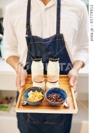 Waiter holding tray with breakfast 65779912