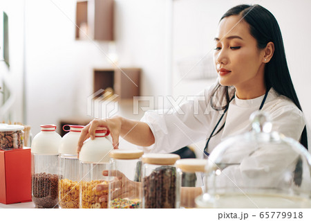 Waitress opening container with cornflakes Waitress opening container with cornflakes 65779918