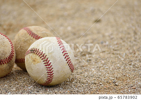 土に転がる3つの野球のボール 硬式ボール の写真素材