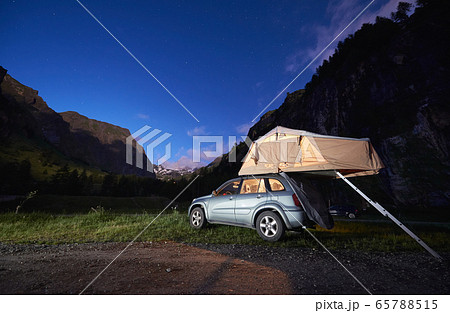 Car with rooftop camping tent in mountains. 65788515