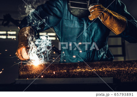 Metal welder working with arc welding machine. 65793891