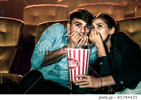 A couple lover watching movie in cinema theater. 65794435
