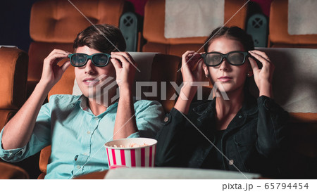 Man and woman in the cinema watching a 3D movie Man and woman in the cinema watching a 3D movie 65794454