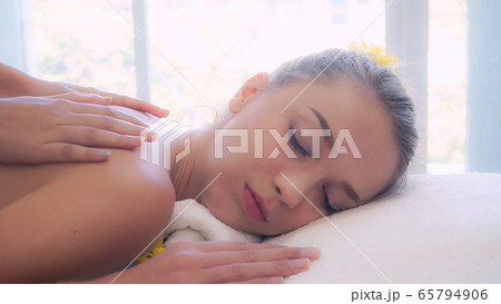 Woman gets back massage spa by massage therapist. 65794906