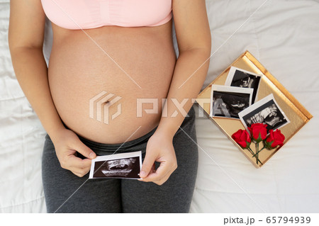 Happy pregnant woman and expecting baby at home. Happy pregnant woman and expecting baby at home. 65794939