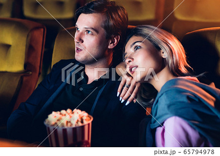 Caucasian lover watching a movie in the cinema Caucasian lover watching a movie in the cinema 65794978
