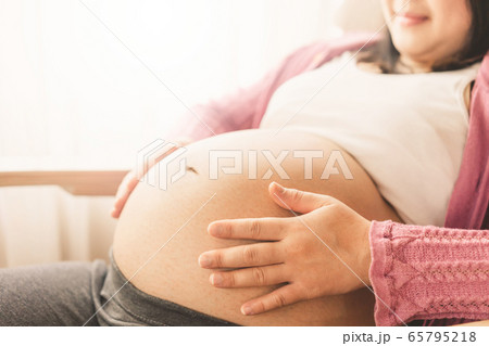 Happy pregnant woman and expecting baby at home. Happy pregnant woman and expecting baby at home. 65795218