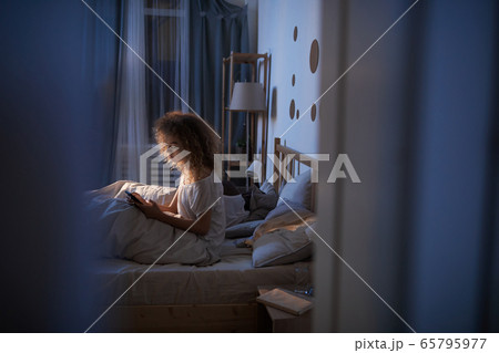 Young Woman Using Digital Tablet in Bed Young Woman Using Digital Tablet in Bed 65795977