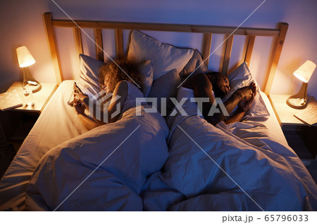 Mixed Race Couple Lying Back to Back in Bed Mixed Race Couple Lying Back to Back in Bed 65796033