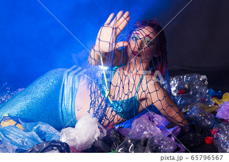 Ocean plastic pollution concept. Mermaid scared due to polluted habitat. 65796567