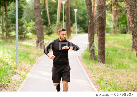 Guy Running Checking Activity Tracker On Wrist Watch Guy Running Checking Activity Tracker On Wrist Watch 65798907