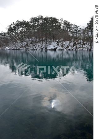 みぞれ混じりの正月、裏磐梯、毘沙門沼の雪景色とコバルトブルーの水面 65799689