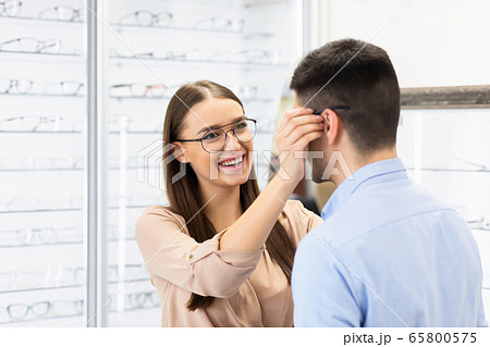 Portrait of lovely young couple choosing spectacles 65800575