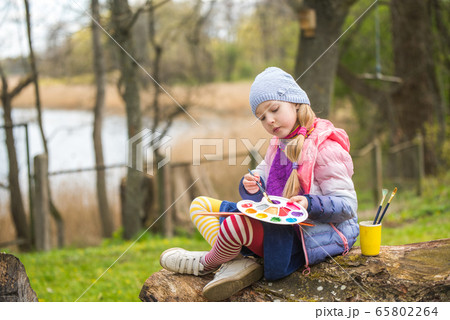 Little girl paints in the spring on nature 65802264