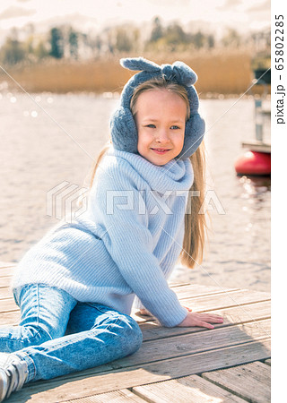 Little girl resting sitting by the river in spring nature Little girl resting sitting by the river in spring nature 65802285