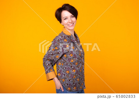 Cheerful woman in home wear pajama studio lifestyle yellow background emotions. Copy space. Cheerful woman in home wear pajama studio lifestyle yellow background emotions. Copy space. 65802833