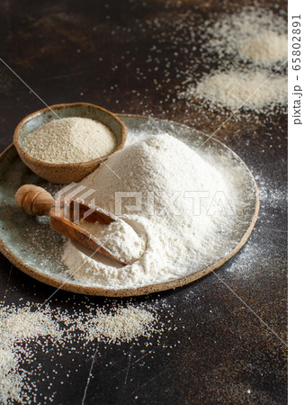 Raw fonio flour and seeds on a plate with a spoon Raw fonio flour and seeds on a plate with a spoon 65802891
