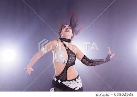 Spirituality dance. Beautiful sexy woman with luxury glossy eastern make-up dancing tribal fusion. Belly dance. Spirituality dance. Beautiful sexy woman with luxury glossy eastern make-up dancing tribal fusion. Belly dance. 65802938