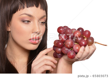 Close up portrait of young woman posing with grapes 65803073