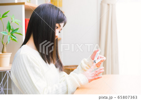 爪を整える女性　コピースペース 65807363