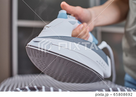 Steam boost on the modern iron. Woman ironing Steam boost on the modern iron. Woman ironing 65808692