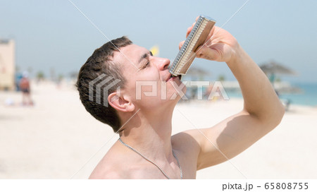 An alcoholic drinks a strong drink from an iron 65808755