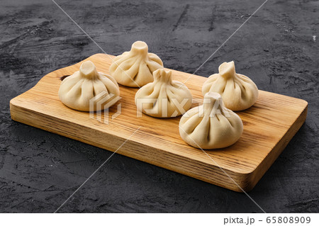 Uncooked khinkali on wooden board 65808909