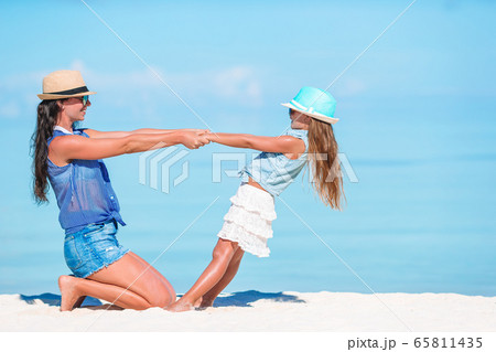 Beautiful mother and daughter at Caribbean beach enjoying summer vacation. Beautiful mother and daughter at Caribbean beach enjoying summer vacation. 65811435