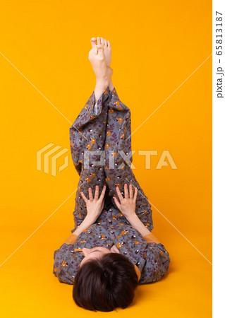 Excited young woman with black hair in home wear pajama, widely smiling having fun. Isolated on yellow background. Copy spase. Excited young woman with black hair in home wear pajama, widely smiling having fun. Isolated on yellow background. Copy spase. 65813187
