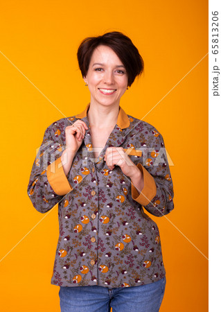Fashion portrait pretty cool girl in home wear pajama having fun over colorful yellow background. 65813206